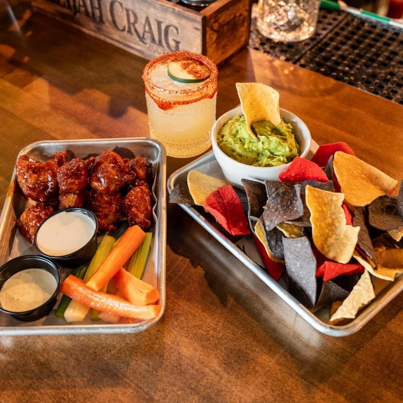 Highline Park's chicken wings with ranch, carrots, celery, guacamole, and colorful tortilla chips.